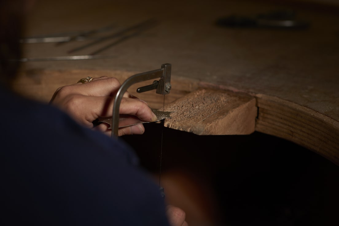 On voit la créatrice Louise Vurpas pour Bijouterie Fine couper une plaque d'argent à l'aide d'un bocfil - Bijouterie Joaillerie, sur-mesure